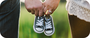 close up of a couple holding a pair of baby shoes